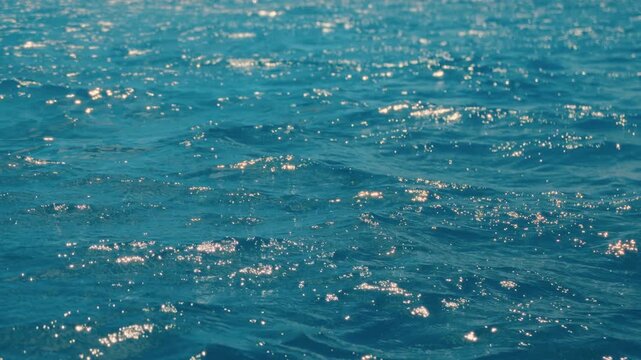 A serene video captures shimmering blue water and gentle waves