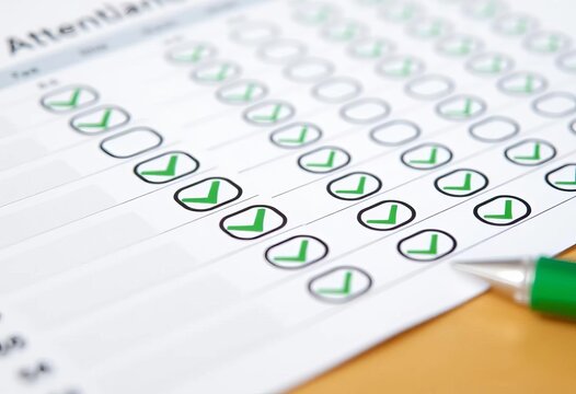 Close-up of office attendance sheet with green checkmarks indicating present employees,  color,  paperwork