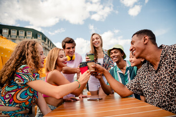 Group of friends enjoying a summer day outdoors with coffee, celebrating togetherness and having...