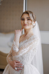 Elegant bride poses gracefully in a stunning wedding dress with intricate beadwork in a bright venue