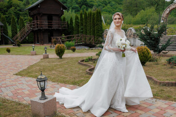 Bride in elegant wedding dress walking through scenic garden path at outdoor venue