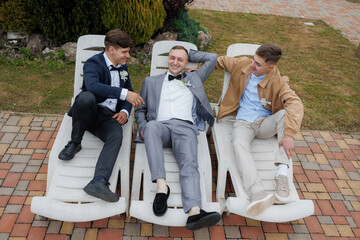 Three friends relax together in lawn chairs during a spring outdoor event
