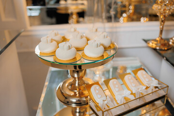 Delicate desserts displayed on a lavish glass stand during a festive gathering