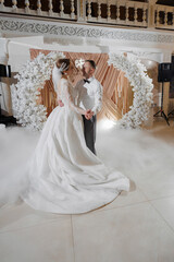 Couple dances together at wedding reception surrounded by elegant floral decorations