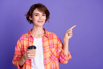 Photo of nice young girl coffee cup direct finger empty space wear shirt isolated on violet color...