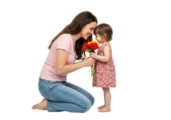 Young caucasian mother in pink t-shirt embraces toddler daughter in patterned dress, holding red/yellow flowers, on a seamless transparent studio background with copy space, no shadows, professional