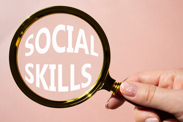Social skills symbol. Concept words Social skills on magnifying glass. Beautiful pink background....