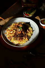 Mutton Mandi Rice. A delicious and hearty bowl of noodles, garnished with fresh herbs and spices, served with a side of vegetables and dipping sauce.