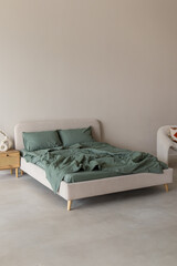 Green bed linen made of boiled cotton. Vertical. Copy space