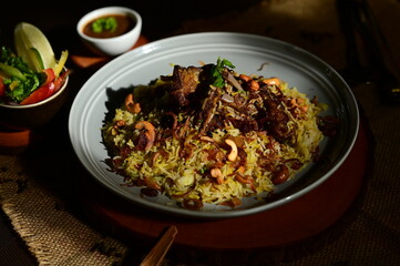 Mutton Mandi Rice. A delicious and artfully prepared seafood omelet with fresh ingredients, presented on a white plate with a side of sauce.