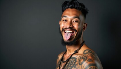 Fototapeta premium Man with tattoos smiling and sticking out his tongue indoors 