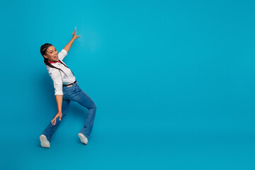 Joyful young woman with stylish fashion on blue seamless background, showcasing vibrant...
