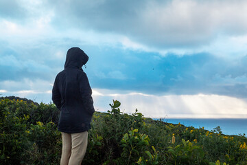 persona mirando hacia el horizonte en un atardecer 