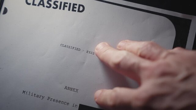 Hand placing secret document with classified information on scanner to be copied. Stealing or revealing confidential government leaked documents. Photocopy or print copy of sensitive intelligence info