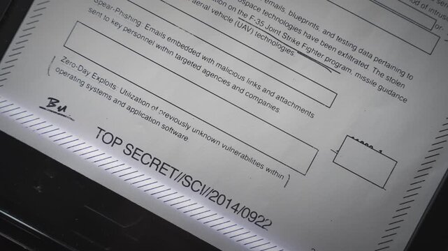 Top secret government document with redacted censored text is photocopied. Report by spy agency or covert classified investigation is passing in digital scanner to computer or illegally copied in leak
