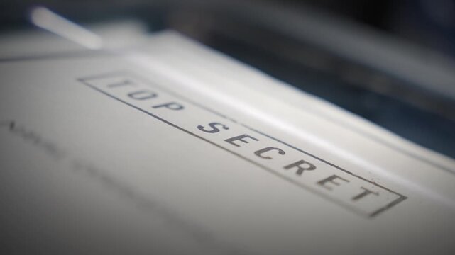 Document lablled Top Secret is being copied or scanned by machine in office. Secret classified information of government agency or spy intelligence gathering is digitized on scanner or printed