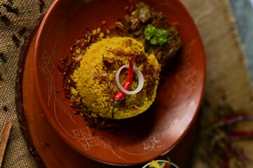 A beautifully presented Beef Khichuri With Green Salad dish with a side of salad and a lemon wedge, served on a rustic wooden surface.