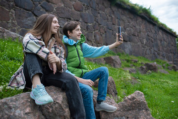 A teenage brother and sister take a selfie with a smartphone in front of the Panzerlaks bastion in...