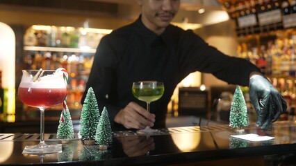 Special drink Midori Sour cocktail with caramelized citrus slice served by bartender serving to...
