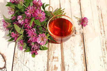 Clover infusion in a glass with a bouquet of flowers, Medicinal herbal tea, the concept of alternative folk medicine, advertising a green pharmacy, a collection of useful herbs 
