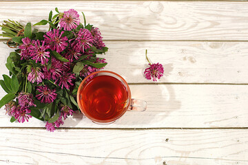 Clover infusion in a glass with a bouquet of flowers, Medicinal herbal tea, the concept of alternative folk medicine, advertising a green pharmacy, a collection of useful herbs for treatment according