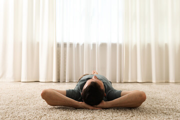 Harmony. Man lying on rug at home