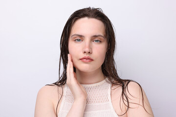 Portrait of beautiful woman with natural skin complexion on light grey background, closeup