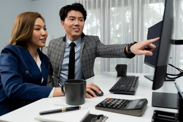 Asian business partners pointing to profit highest dynamic stock exchange data on computer screen...