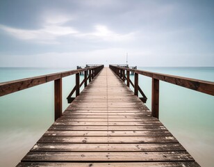 Fototapeta premium Calm wooden pier extends into a tranquil sea