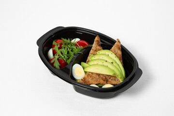 Toasts with avocado, tomatoes, arugula, and boiled eggs on a plate, isolated on white background