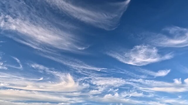 Fluffy clouds in the blue skies mooving left side. 4K video (Ultra High Definition) of cloudscape. Sky and clouds Timelapse. Sun shines through the clouds on the blue sky background.