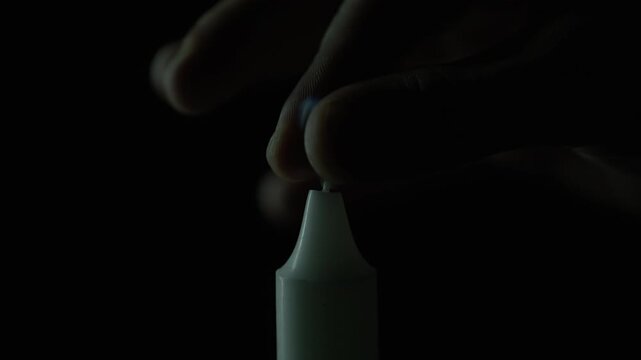 Fingers squeezing candle fire on black background closeup. Person snuffing wax