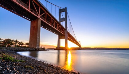 Obraz premium Cable-stayed bridge at sunset over a calm river
