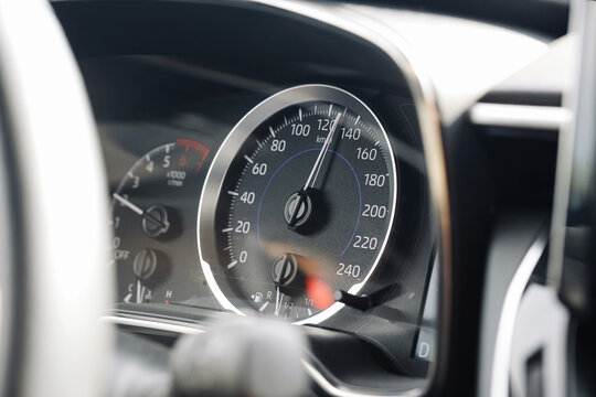 Modern car speedometer dashboard. Closeup of analog speed gauge in vehicle. Black dial with white numbers. High speed performance panel. Driving control and automotive instrument detail.