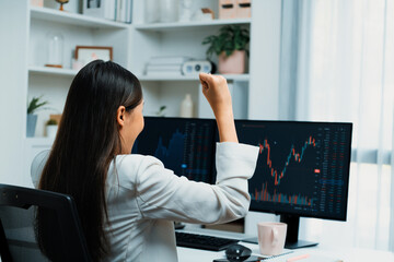 Successful young Asian businesswoman earning highest profit with fist up in exchange stock market...