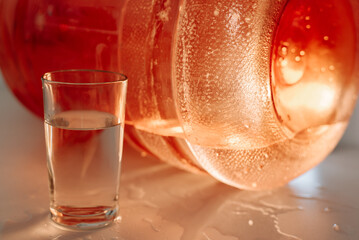 Minimalist composition with lemon slices and a glass of water on light surface, top view.