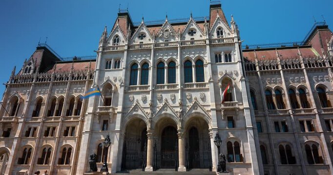 Budapest, Hungary - June 14, 2025: Hyperlapse of Budapest Parliament on a hot, cloudless summer day. Zoom in transition.
