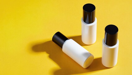 Three white bottles with black caps on yellow background