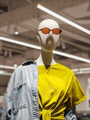 Fashion display featuring a stylish mannequin with sunglasses in an urban retail store