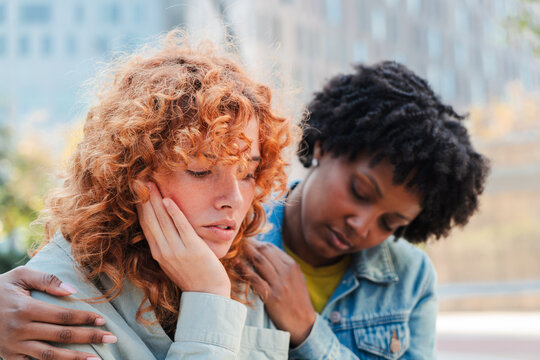 Two women engage in a supportive moment where one friend offers comfort and empathy to another experiencing emotional distress and sadness, showcasing the importance of friendship and support.