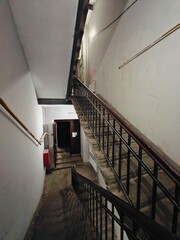 Stairway leading down to a dimly lit entrance in an old building with a rustic charm and worn steps