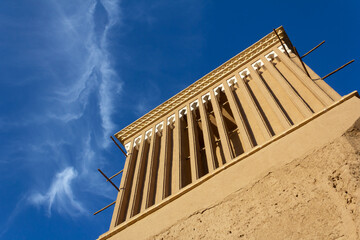 Close-up of a traditional windcatcher (badgir) against a vibrant blue sky in Yazd, Iran—an iconic element of Persian desert architecture.

