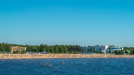 Finland. Sandy beach of Oulu city. Many people relax on a hot summer day on the sea beach.