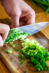 Chopping Green Onions on Rustic Wooden Cutting Board