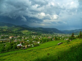 An idyllic and charming remote village, cradled by lush green hills and distant peaks