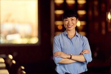 Confident Professional Woman Smiling at the Camera in a Warmly Lit Office Space