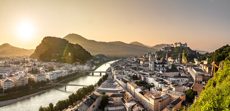 View of Salzburg from Monchsberg hill at sunrise, with Salzach river, castle and hills in background