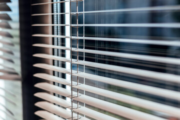 Sunlight coming through venetian blinds by the window