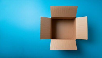 Obraz premium open cardboard box on blue background showing empty interior space top view