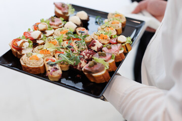 Colorful appetizers served on a platter at a formal event during the evening